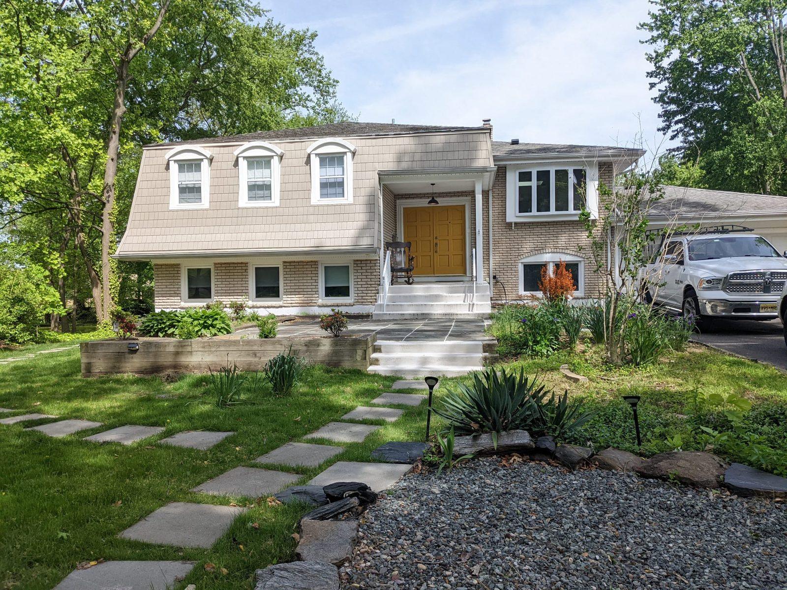 Renovated home exterior with a bluestone walkway and refreshed landscaping