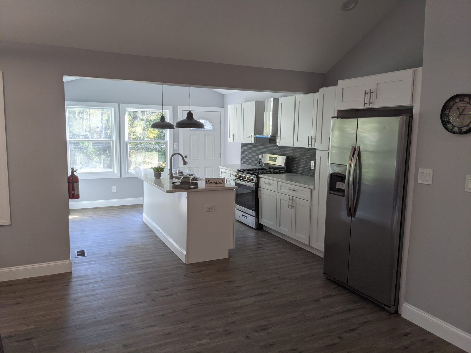Completed kitchen with a centre island, shaker cabinetry and full appliance package