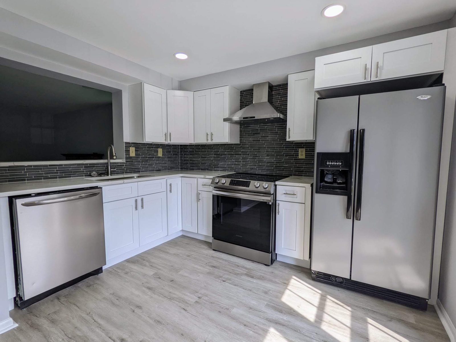 White shaker kitchen with a dark glass mosaic backsplash