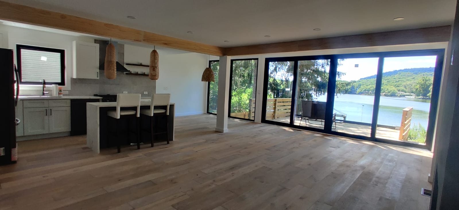 Open living and kitchen space with wide-plank oak floors and sliding glass