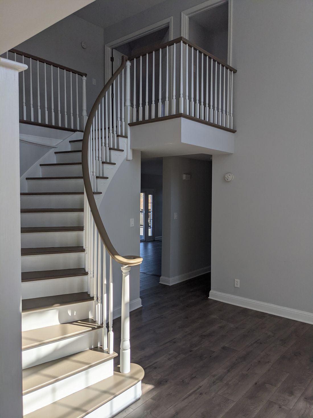 Curved staircase with a painted balustrade and new hardwood treads