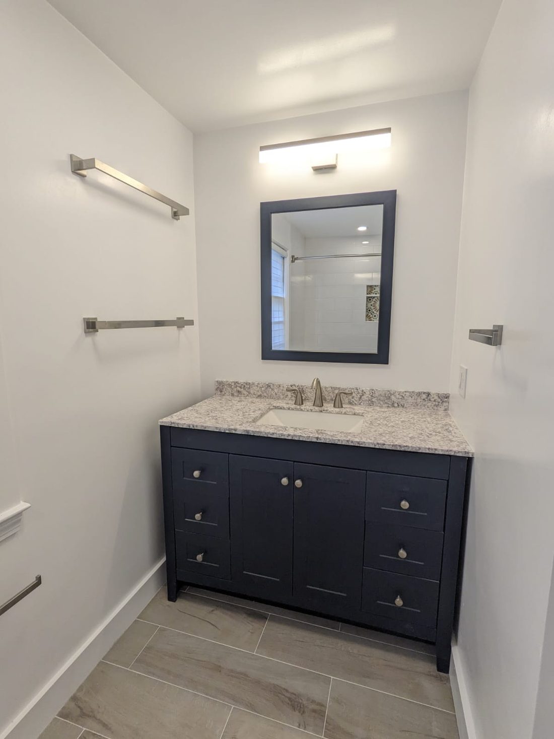 Navy shaker vanity with a speckled granite top